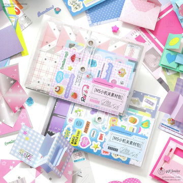 Colorful DIY scrapbook kit with stickers, papers, and envelopes laid out on a desk