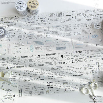 Transparent washi tape sheets with minimalist doodles and motivational quotes laid out on a desk with scissors and stationery.