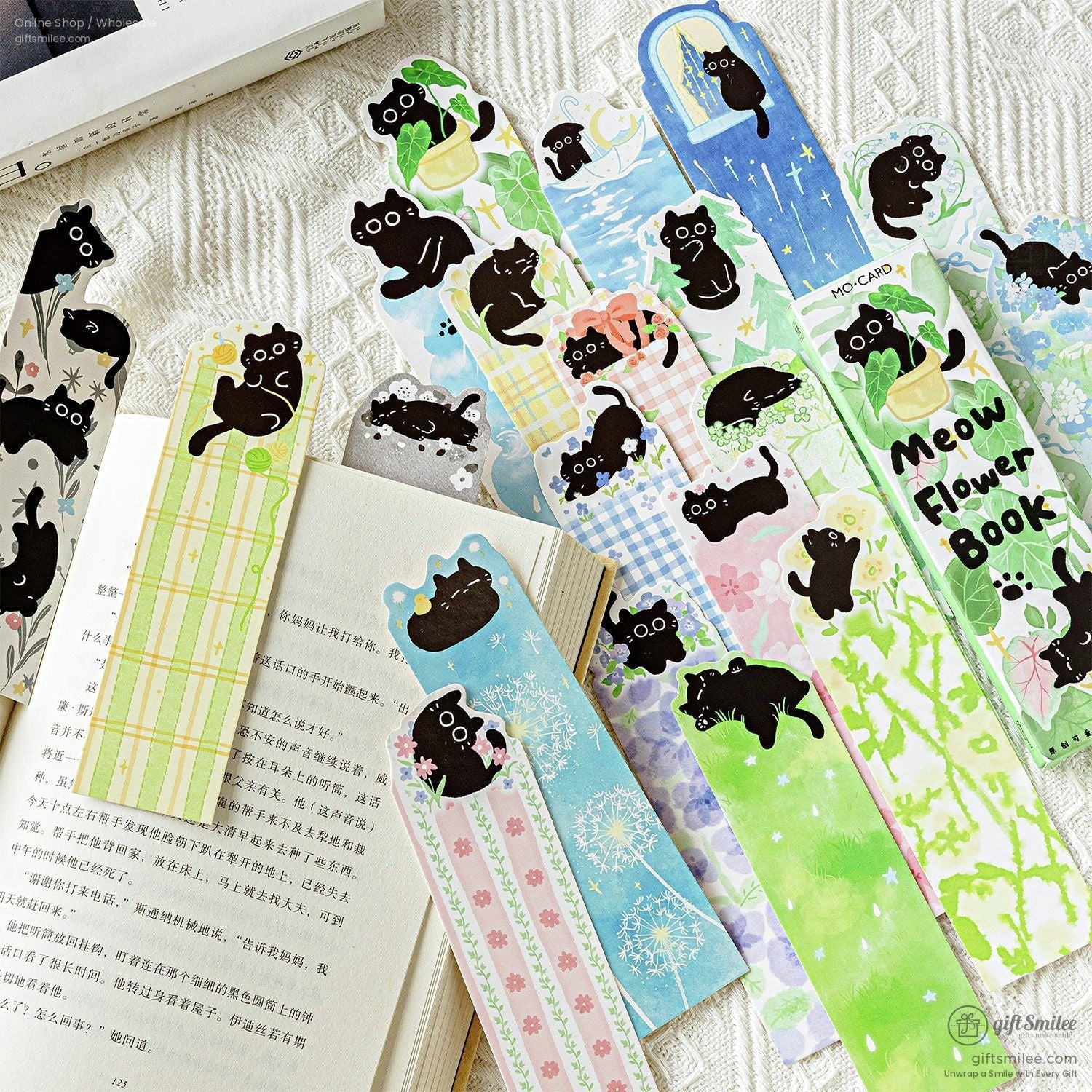 Cute black cat illustrated bookmarks set, floral and pastel designs laid out with an open book