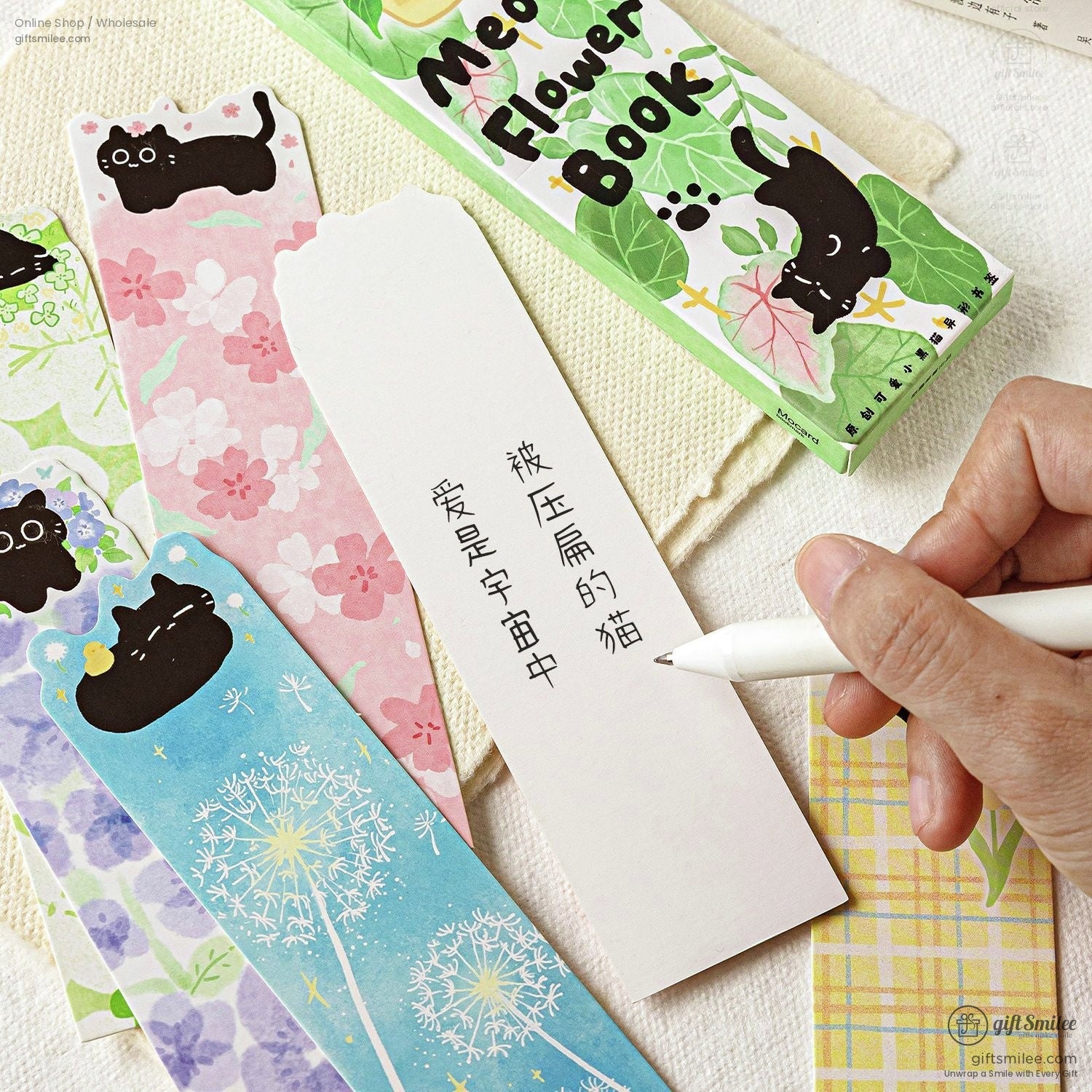 Cute cat-themed floral bookmarks with pastel designs and a hand writing on a blank bookmark