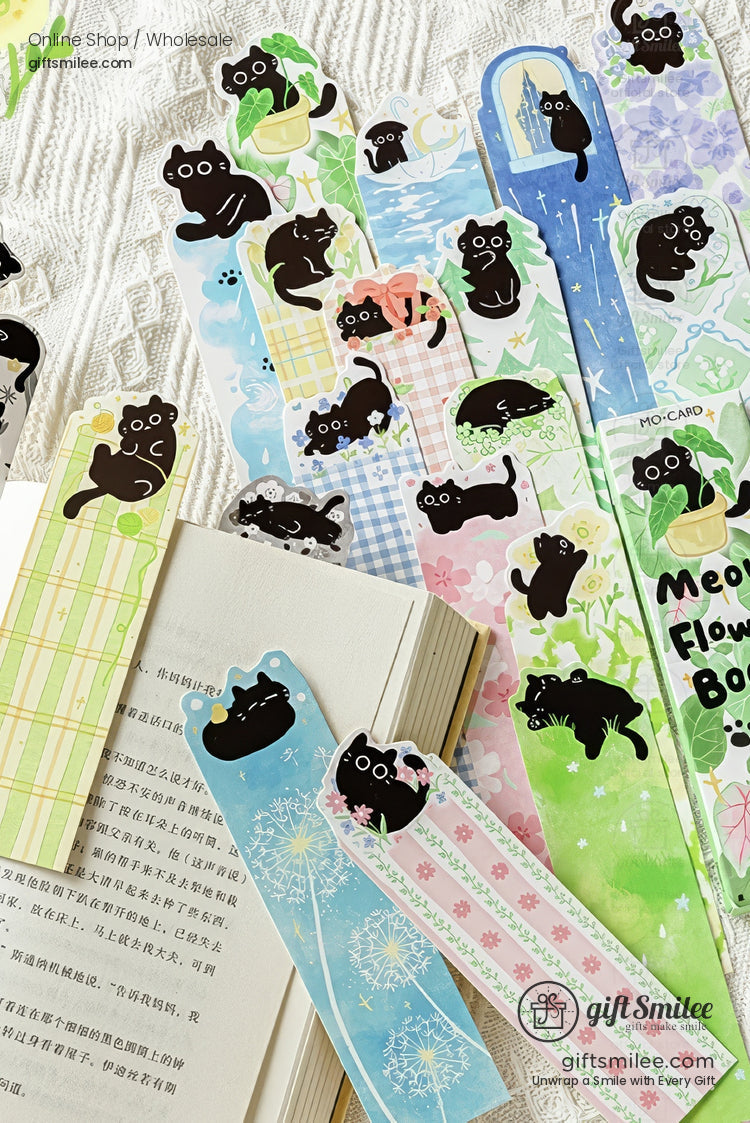 Cute black cat bookmarks set with floral and pastel designs on open book  