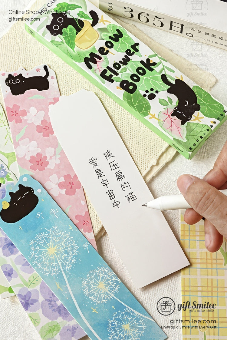 Cute black cat illustrated bookmarks on cozy blanket and open book, floral and plaid designs.