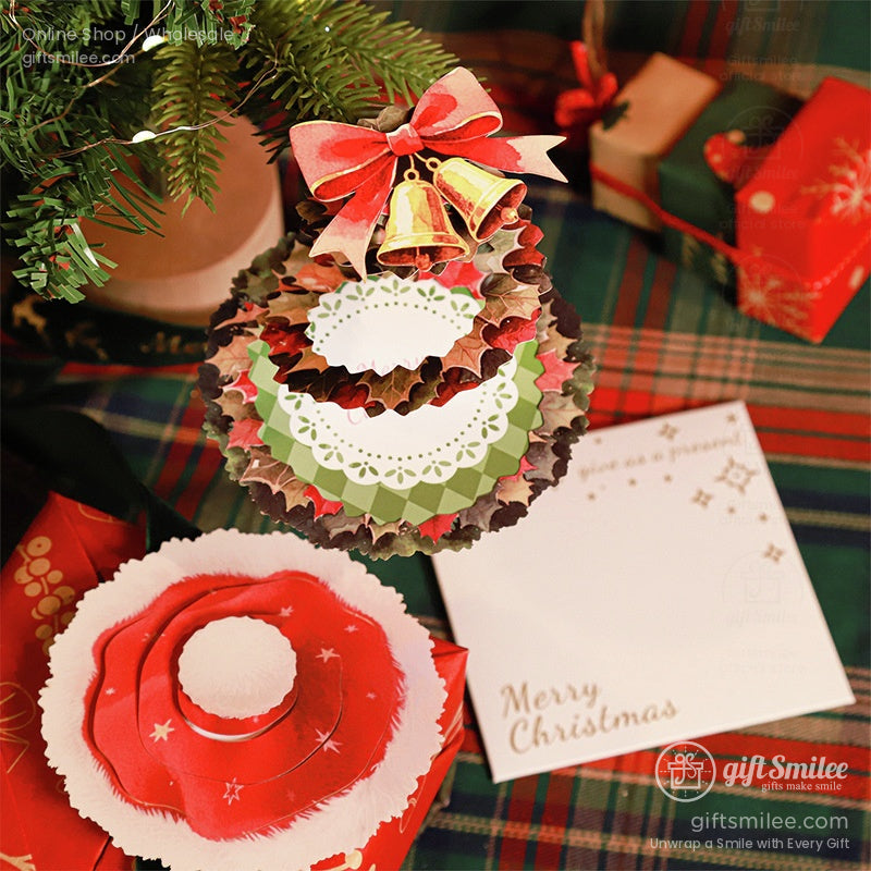 Handmade Christmas card featuring a layered holiday ornament design with bells and a red bow