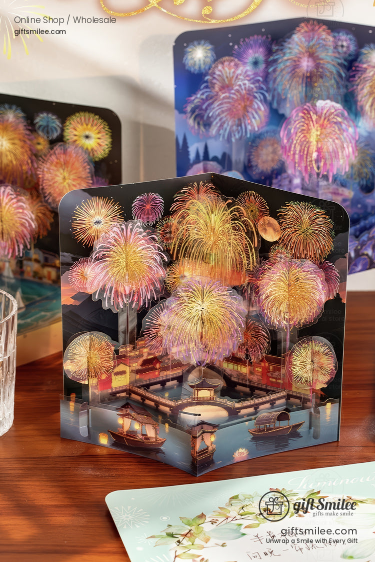 Vibrant popup card showcasing multicolored fireworks over a serene lakeside village with illuminated traditional boats