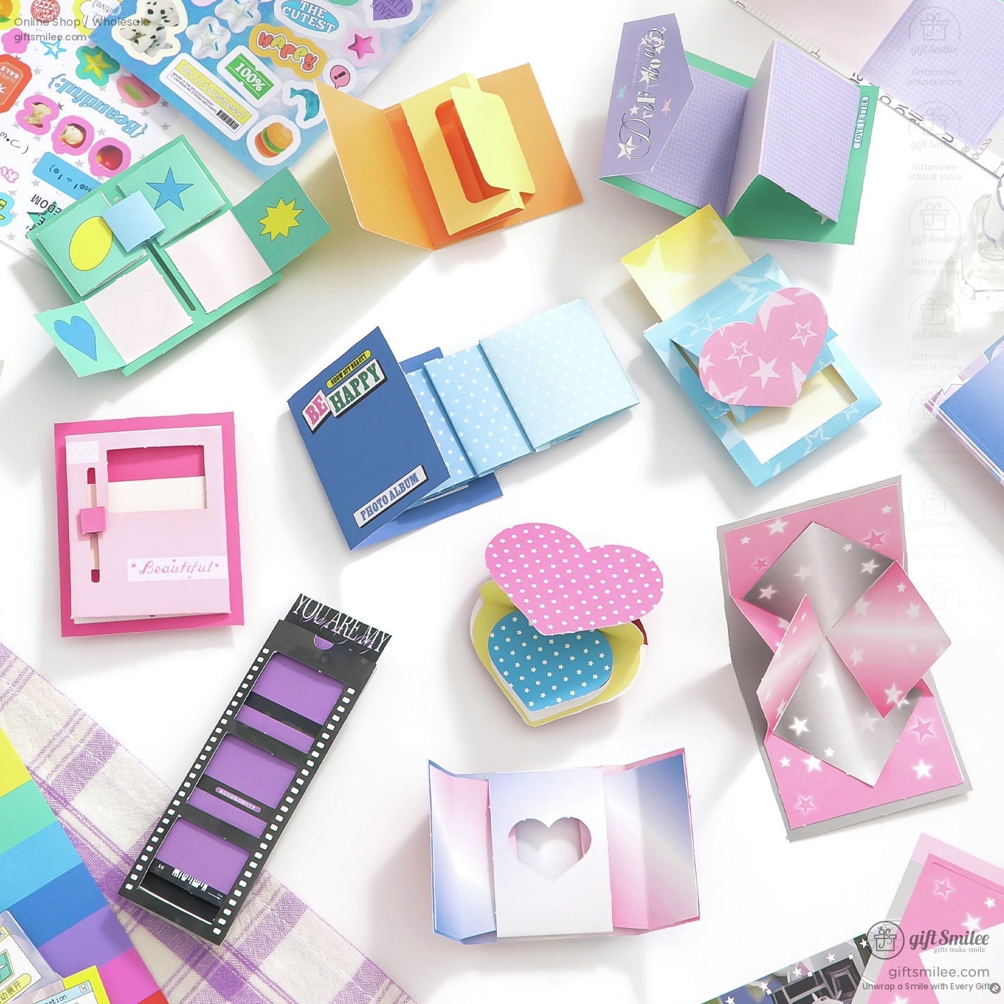 Colorful DIY scrapbook kit with stickers, envelopes and paper mechanisms laid out on a desk