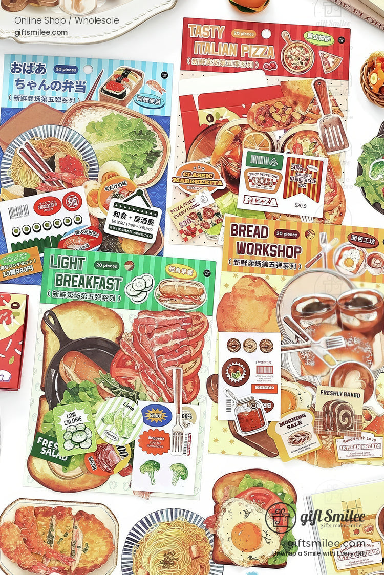 Food-themed scrapbook stickers with bread, pastries, and dessert drinks arranged around an open planner.