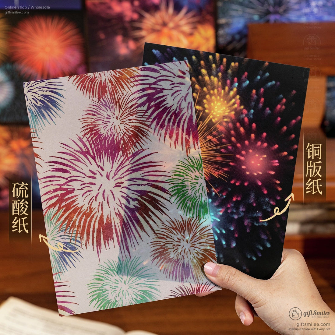 Fireworks-themed wrapping paper sheets showing matte and glossy finishes held by hand  