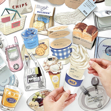 Assorted paper cutouts of colorful food items drinks and household objects including ice cream cookies and a milk cup