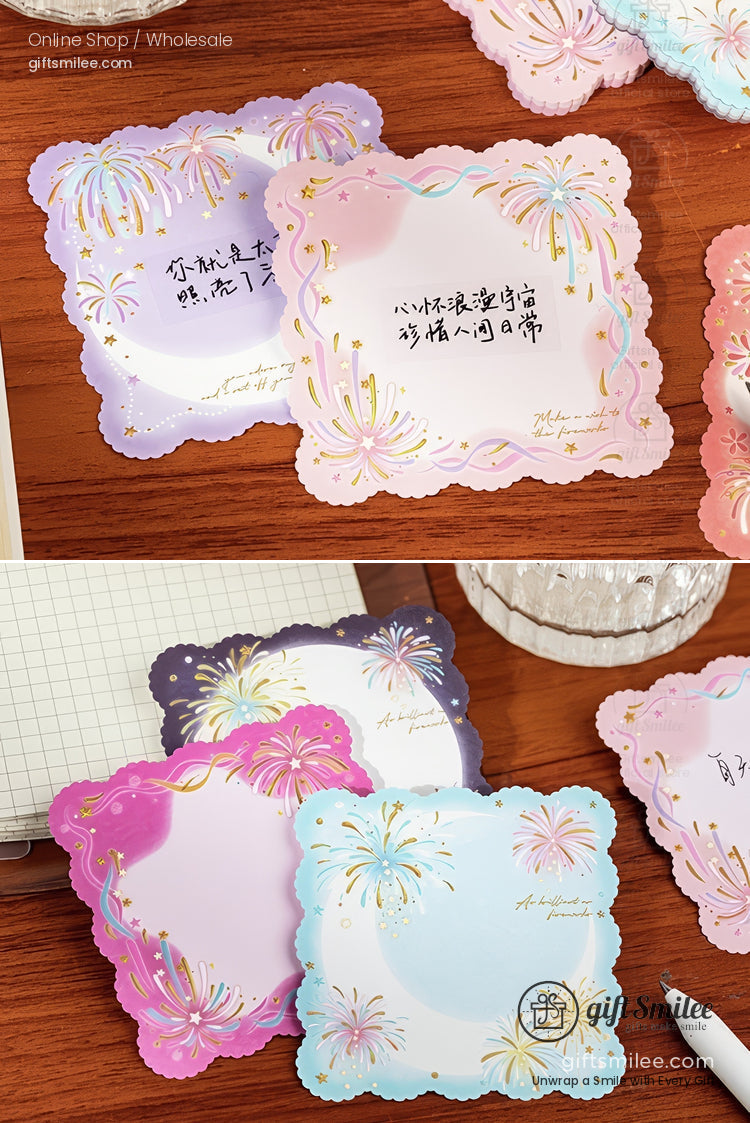 Scalloped pastel stationery cards with gold foil fireworks featuring lavender pink and blue tones on a wooden surface