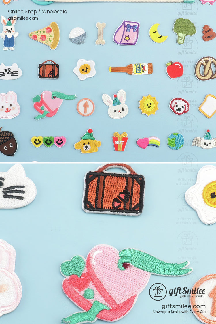 Assorted colorful embroidered patches including a pink heart with an arrow brown suitcase bunny pizza and rainbow