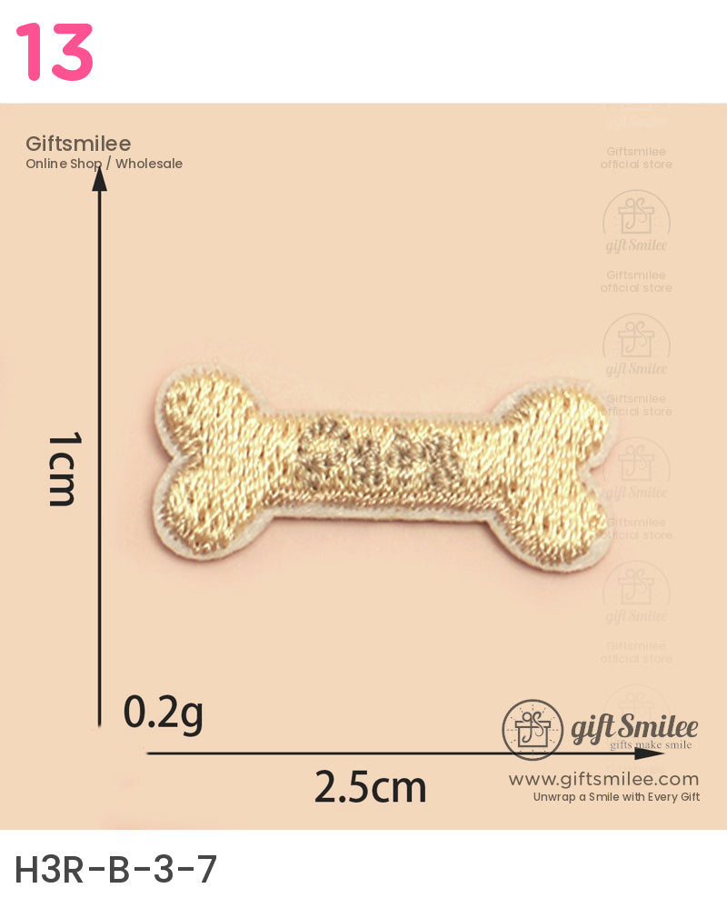 Gold embroidered boneshaped patch 25cm by 1cm lightweight fabric with a shiny finish on a beige background