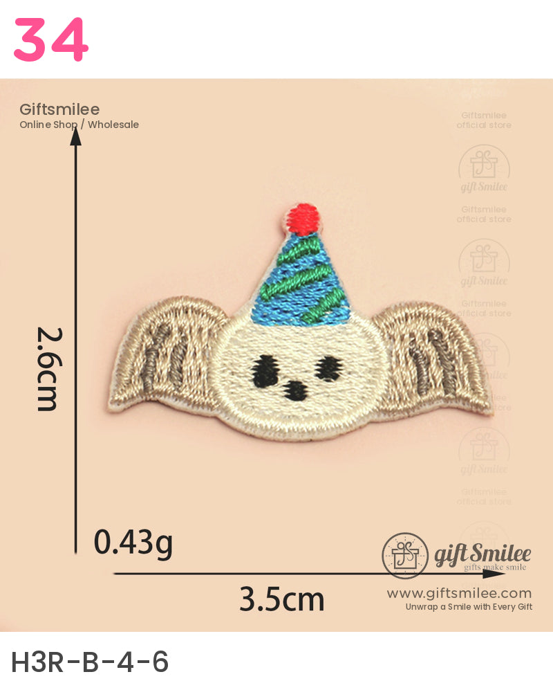 Beige embroidered patch with bat wings a white face black eyes and a festive greenblue party hat with red tip
