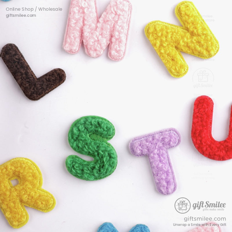 Multicolored crochet alphabet letters of 25 cm size on white ceramic plate featuring vibrant textures and playful design