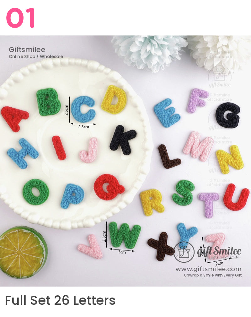 Colorful crocheted uppercase alphabet letters in various hues including red green and yellow displayed on a white plate