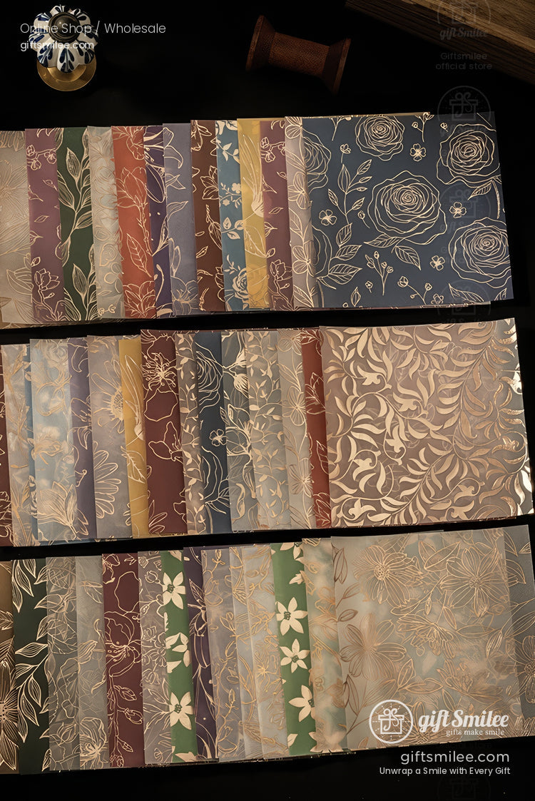 Assorted floral-patterned wrapping paper sheets in various colors with gold foil designs, displayed flat for gift packaging.