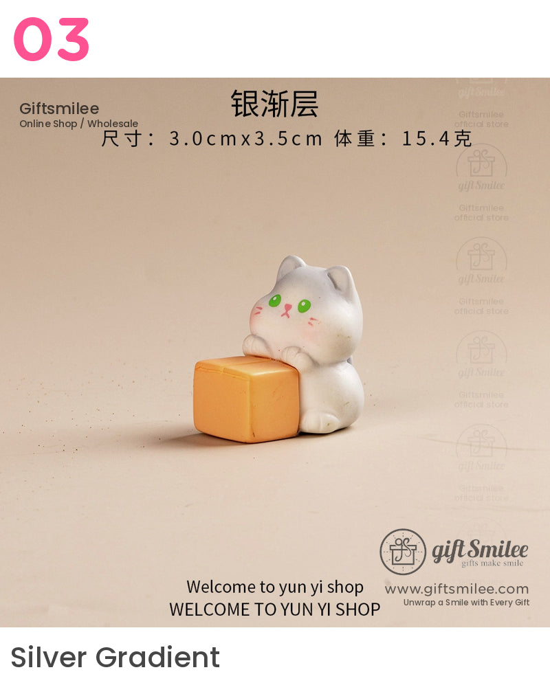 White ceramic cat figurine with green eyes holding an orange cube minimalist design on a beige background