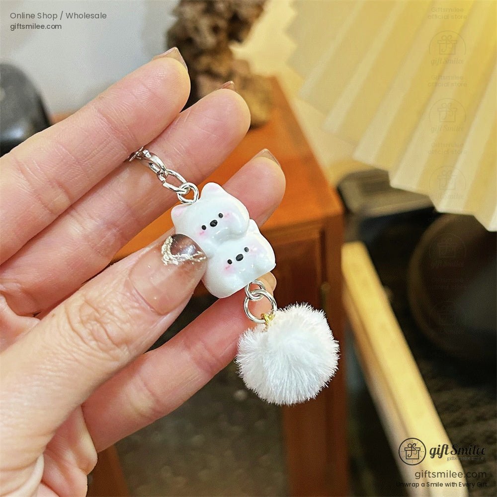 Pastel ceramic cat charms in white pink and yellow hung on silver straps accented with soft white fauxfur pompoms