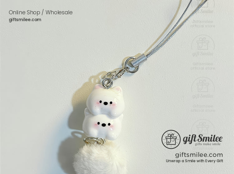 White plush pompom charm with stacked catshaped ceramic beads black facial details and a silver strap attachment