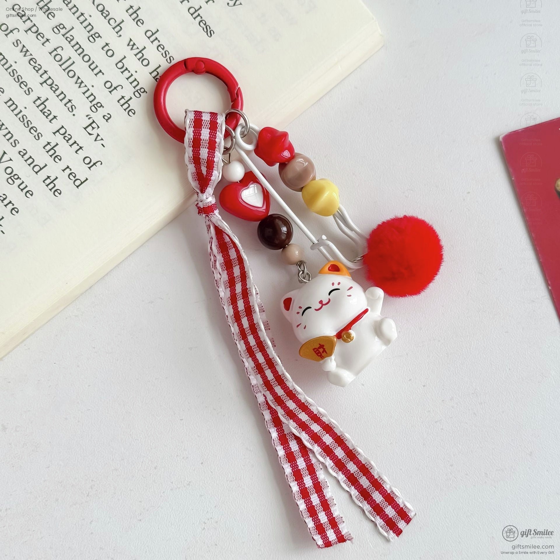 Red and white gingham ribbon keychain with lucky cat charm colorful beads heart detail and fluffy pompom accessory