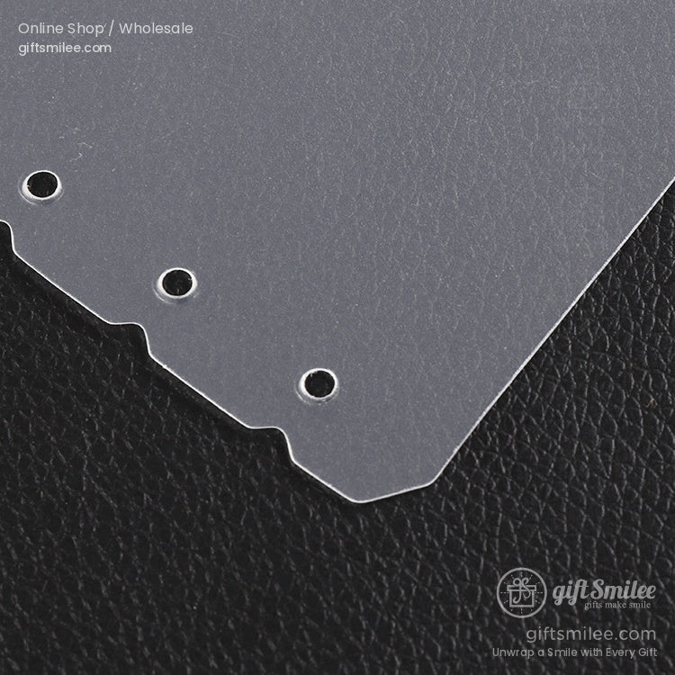 Transparent plastic divider with three punched holes rounded edges and smooth finish on black textured surface