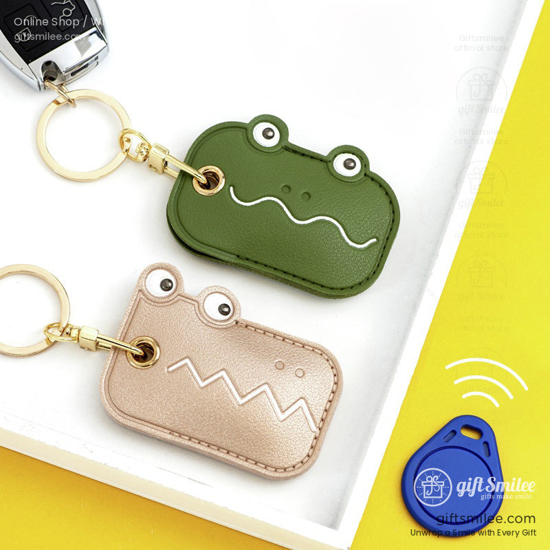 Green and beige crocodileshaped leather key fobs with gold key rings accented with playful embossed details