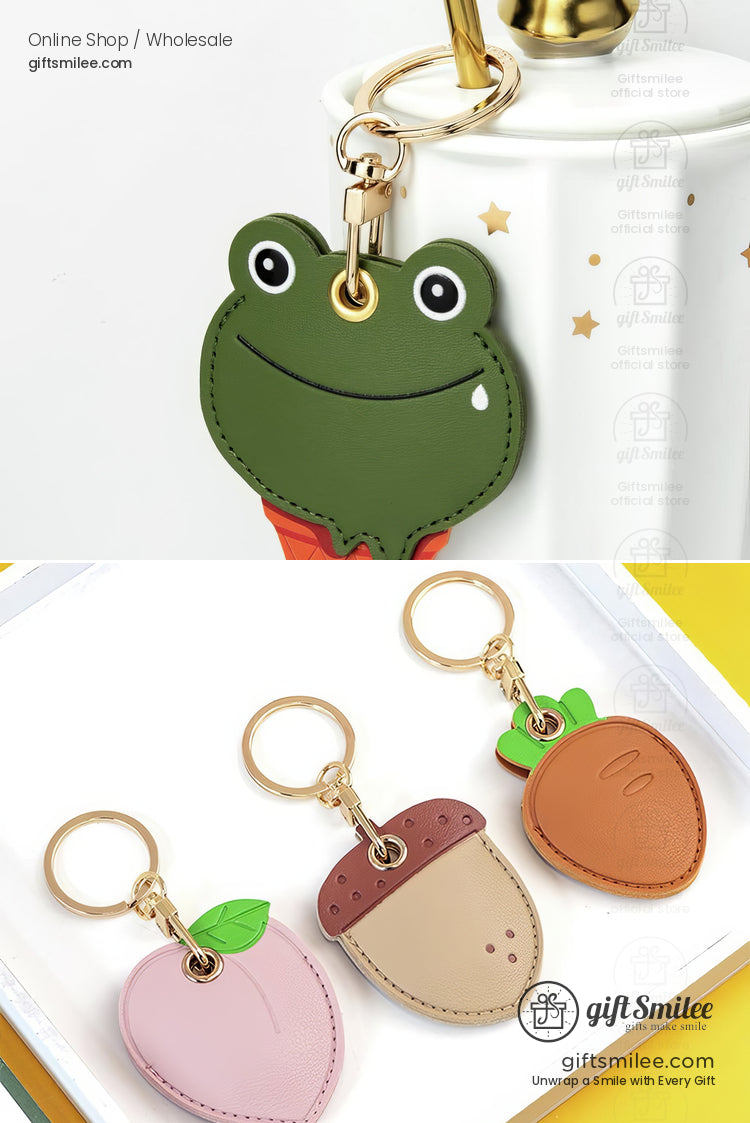 Green frogshaped leather keychain with gold hardware and pastel fruitthemed keychains of peach mushroom and orange