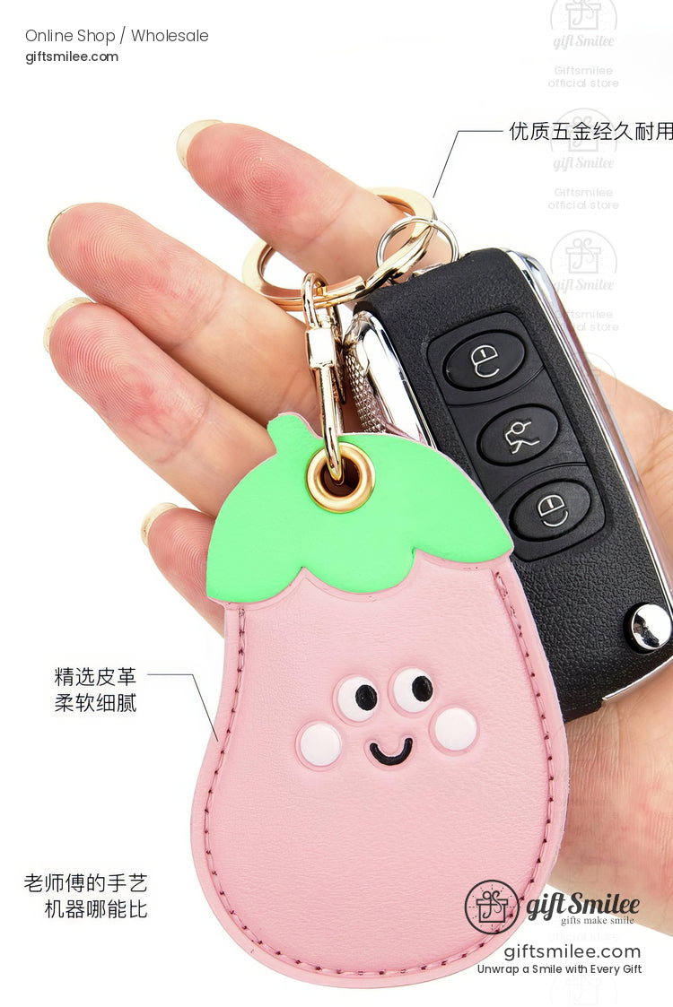 Pink leather eggplant keychain with a green top cute smiling face and a durable goldtone metal keyring clasp