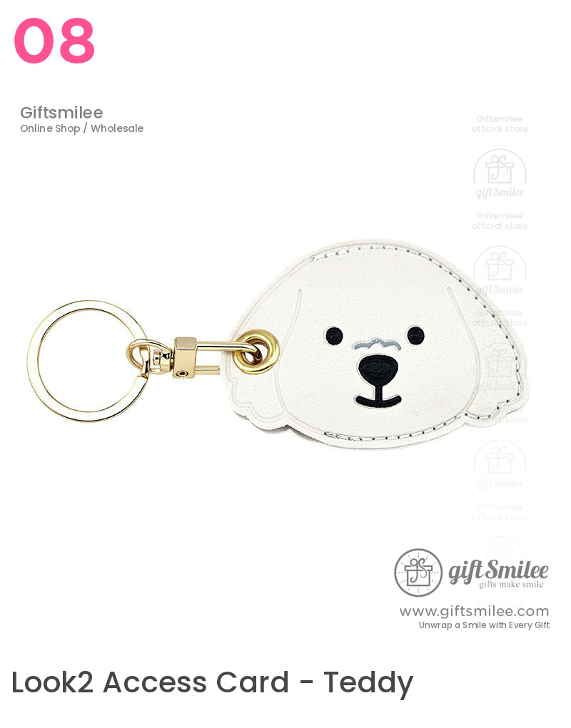 White faux leather dogshaped keychain with stitched details black facial features and a goldtone metal ring clasp