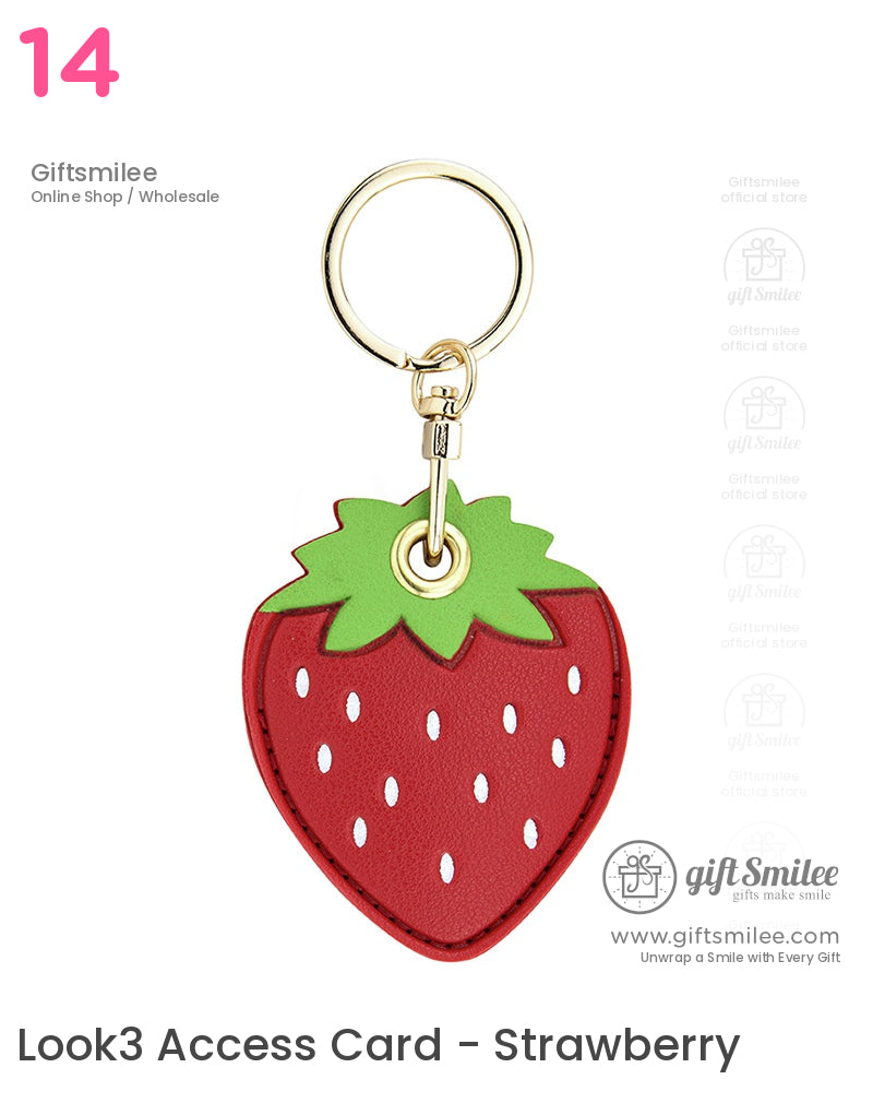Red strawberryshaped faux leather keychain with green leaf detail white seeds and gold metal ring clasp