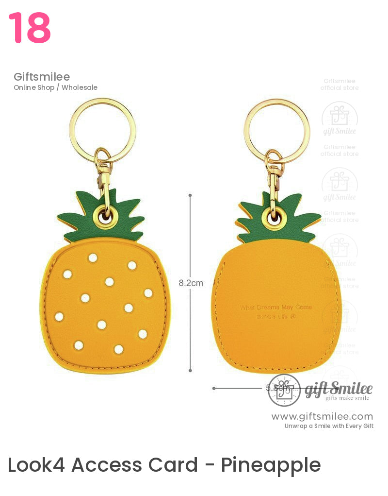 Yellow pineappleshaped faux leather keychain with green leafy top goldtone metal ring and white polka dot accents