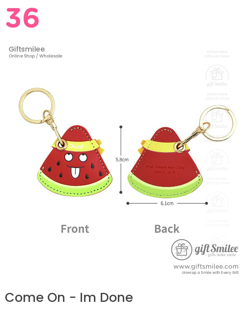 Red watermelonshaped leather keychain with gold ring green rind detail cartoon face and Dead text on yellow strap