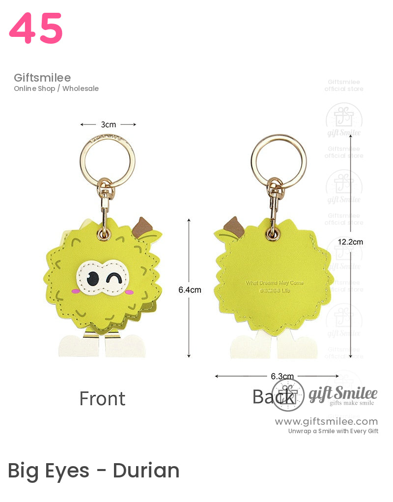 Green cartoon durian keychain with a winking face brown stem detail white legs gold keyring and engraved lettering