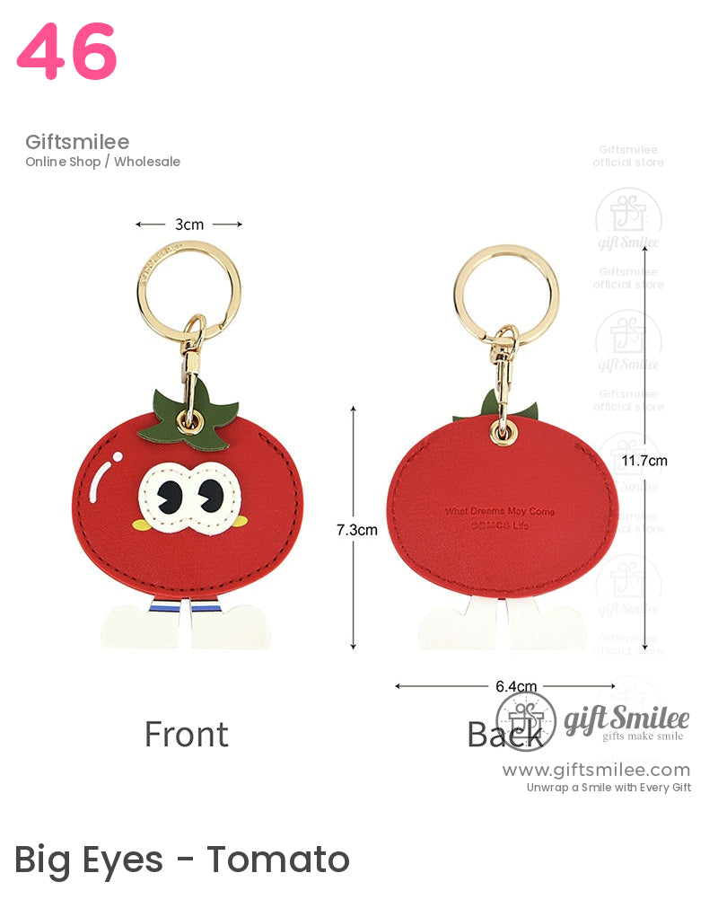 Red tomatoshaped leather keychain with green leaf detail gold ring clasp cartoon eyes and white feet accents