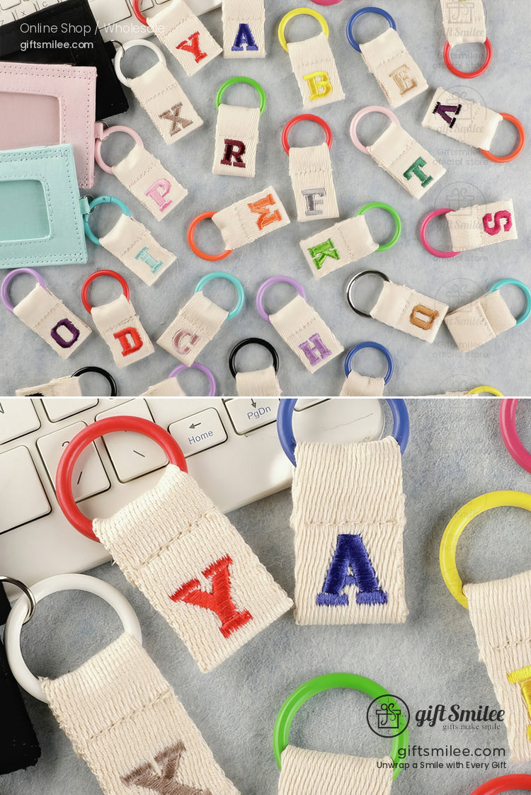 Colorful embroidered letter keychains with canvas straps and vibrant plastic rings perfect for personalization