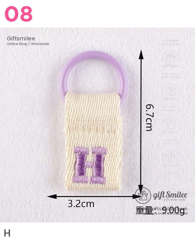 Cream cotton keyring with purple embroidered H and lavender plastic loop measuring 67cm by 32cm 9g weight