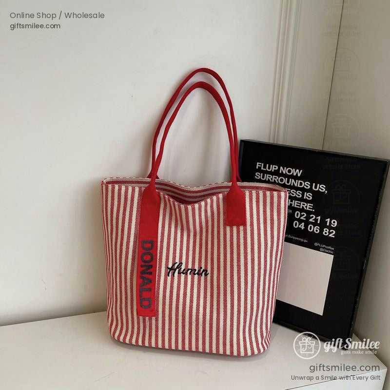 Red and white striped canvas tote bag with bold red handles Donald text on strap and embroidered Amin detail