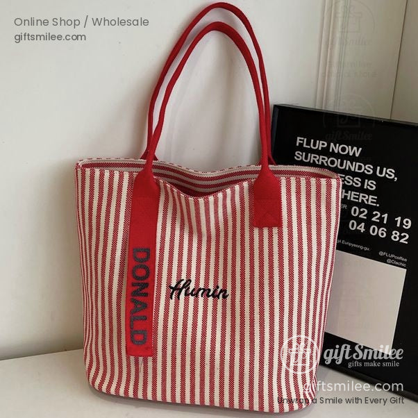 Red and white striped tote bag with bold red handles embroidered Donald strap and Amim text on the front
