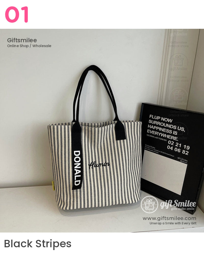Beige and black striped canvas tote bag with black handles Donald tag embroidered human text and minimalistic design