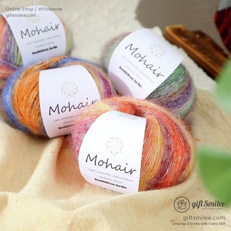 Multicolored mohair yarn balls with soft gradient hues of orange pink purple and green on a beige fabric background
