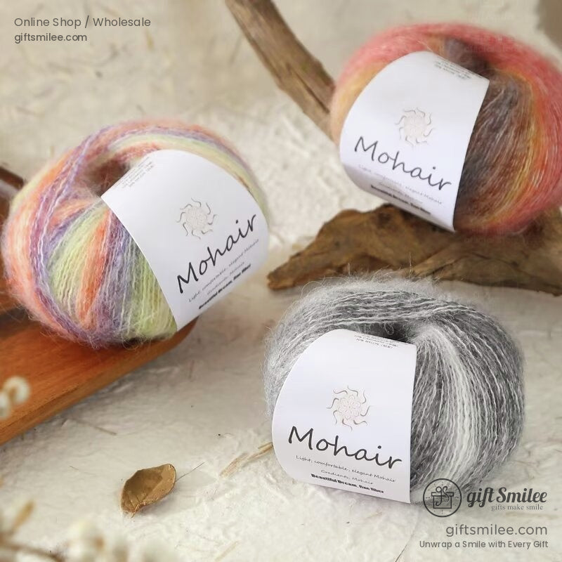Soft mohair yarn balls in pastel rainbow coral orange and gray tones arranged on natural wood and textured surface