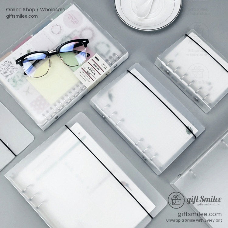 Frosted translucent notebook covers with elastic bands spiralbound inserts and minimalist gray desk setup