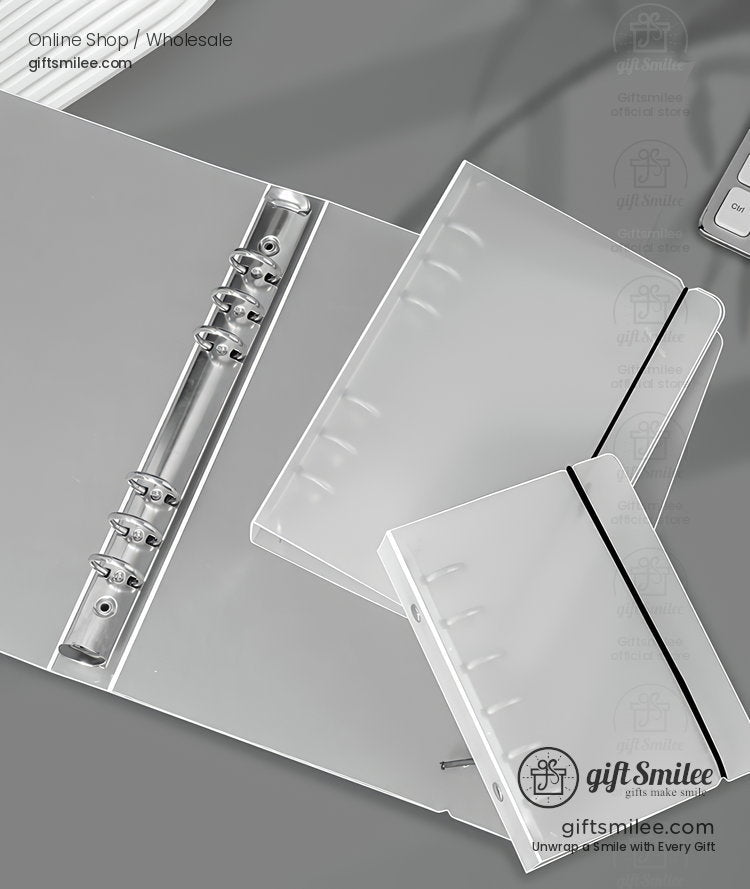 Transparent frosted plastic binders with metal rings elastic closures and modern sleek design on a gray surface