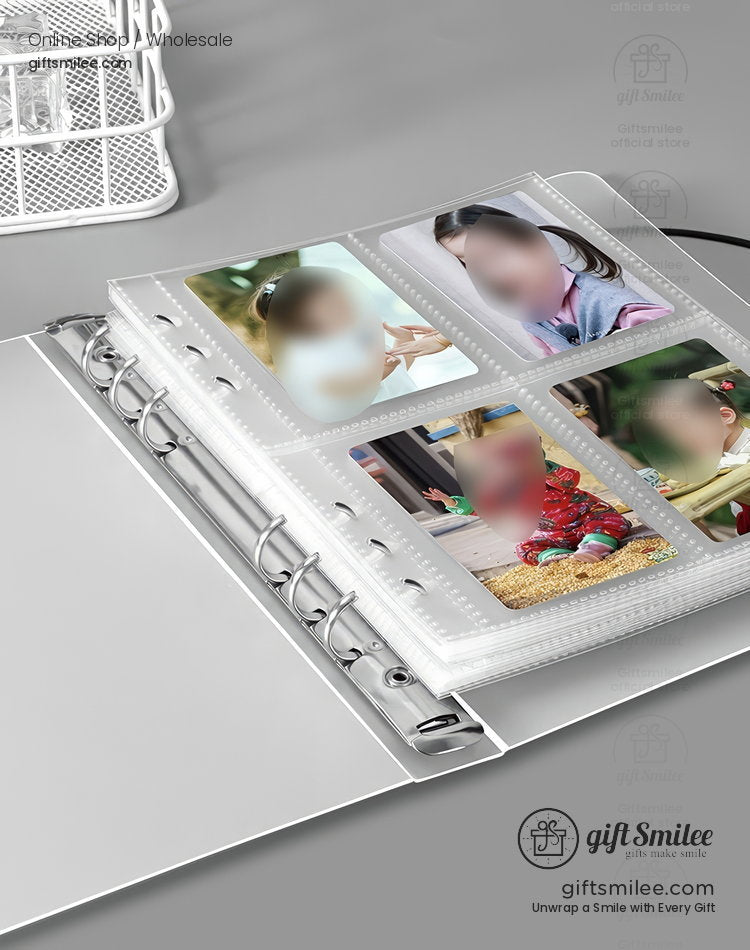 Clear plastic photo album with ring binder design holding colorful printed images displayed on a gray desk