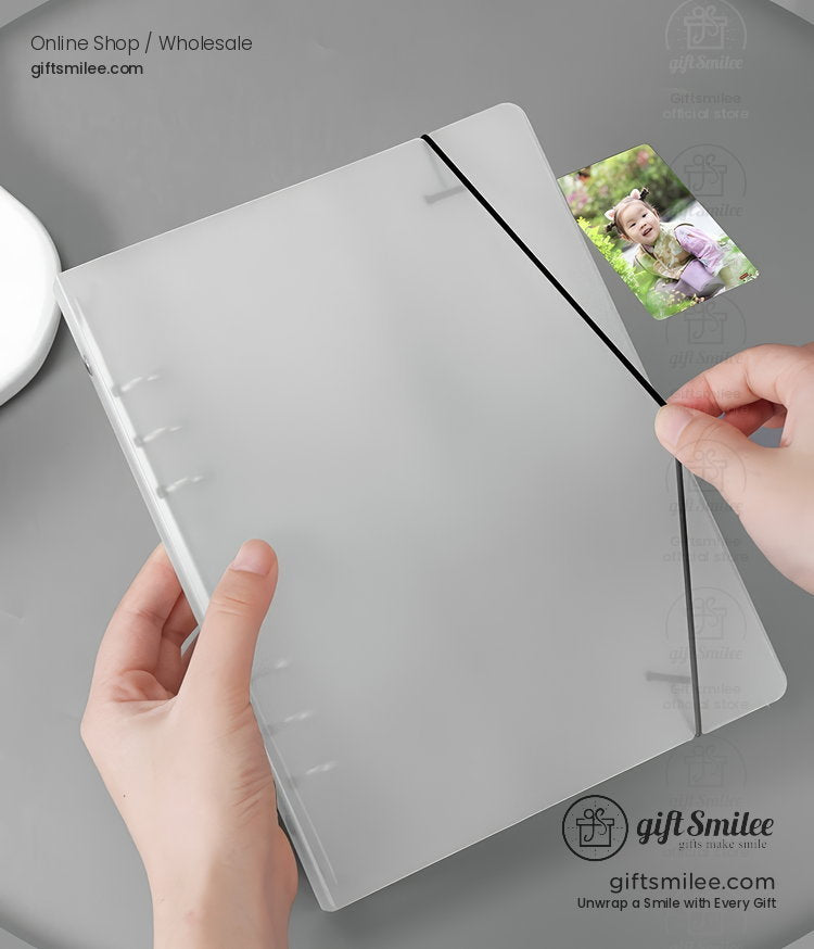 Transparent frosted plastic notebook cover with black elastic band closure and refillable ring binder design