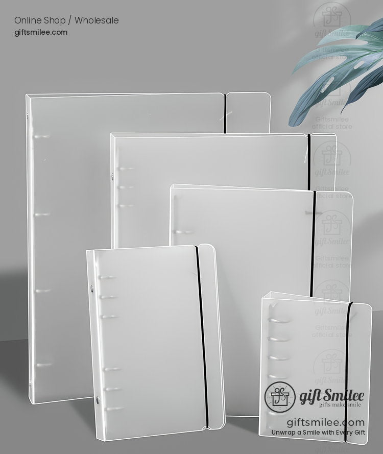 Transparent plastic notebooks in various sizes with black elastic bands and smooth covers displayed on a gray surface