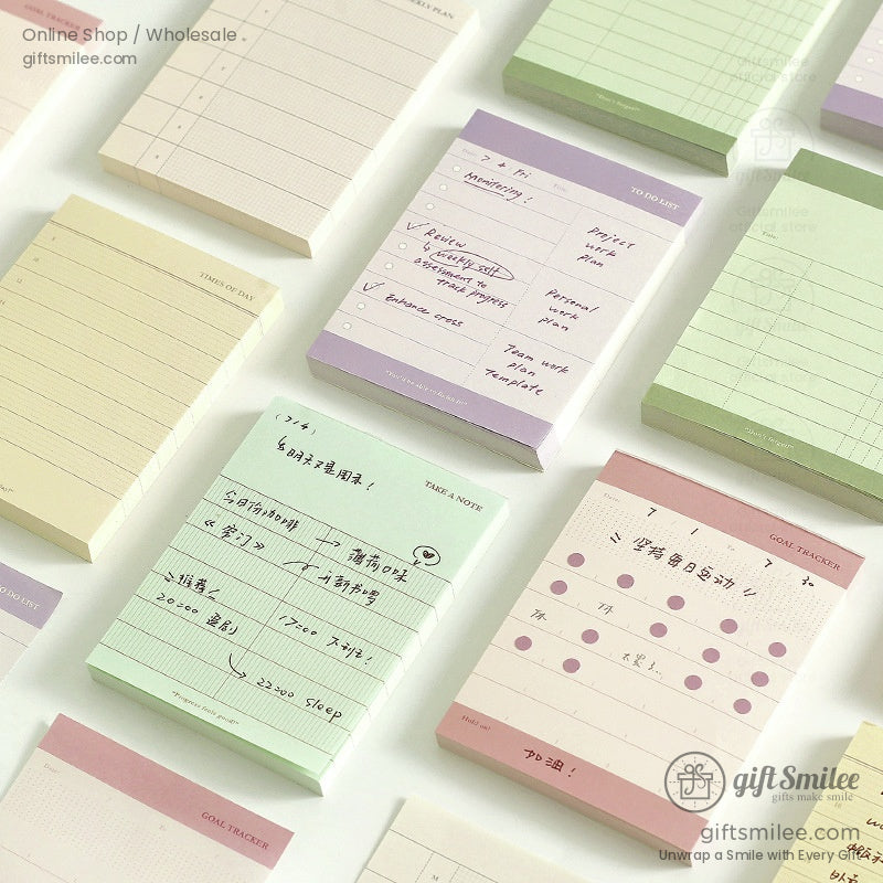 Pastel-colored daily planner pads with handwritten notes and grid designs