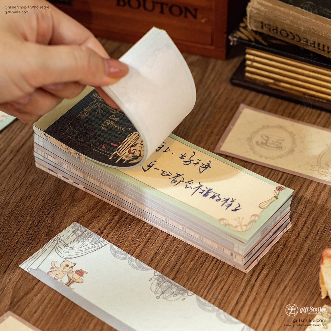 A collection of vintage cat-themed memo pads with intricate designs and floral accents on a wooden desk