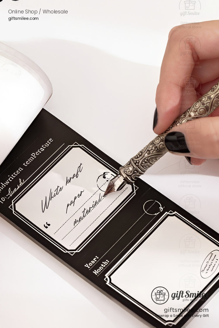 Hand holding ornate fountain pen writing on a black and white message notepad from giftsmilee, close-up stationery product shot.