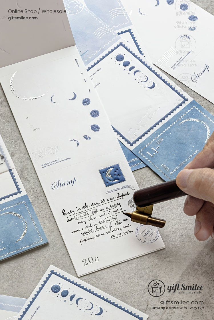 Blue moon-themed stationery set with wax seal stamp on desk, featuring celestial stamps and silver foil accents from giftSmilee.