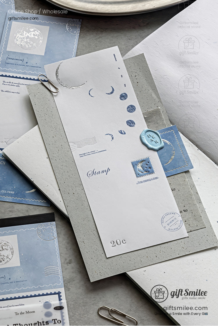 Minimalist blue and gray stationery set with moon-themed stamps and wax seal on a white letter, flat lay for journaling and scrapbooking.